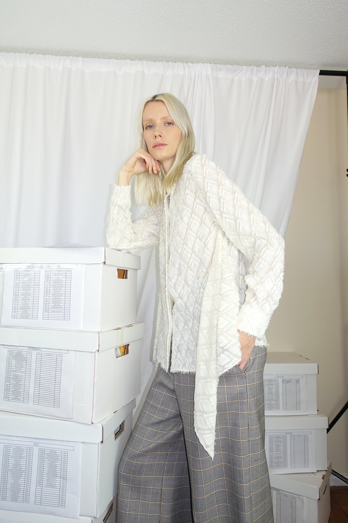 Woman wearing an ivory flowy blouse with fluffy fabric and loose waist detail