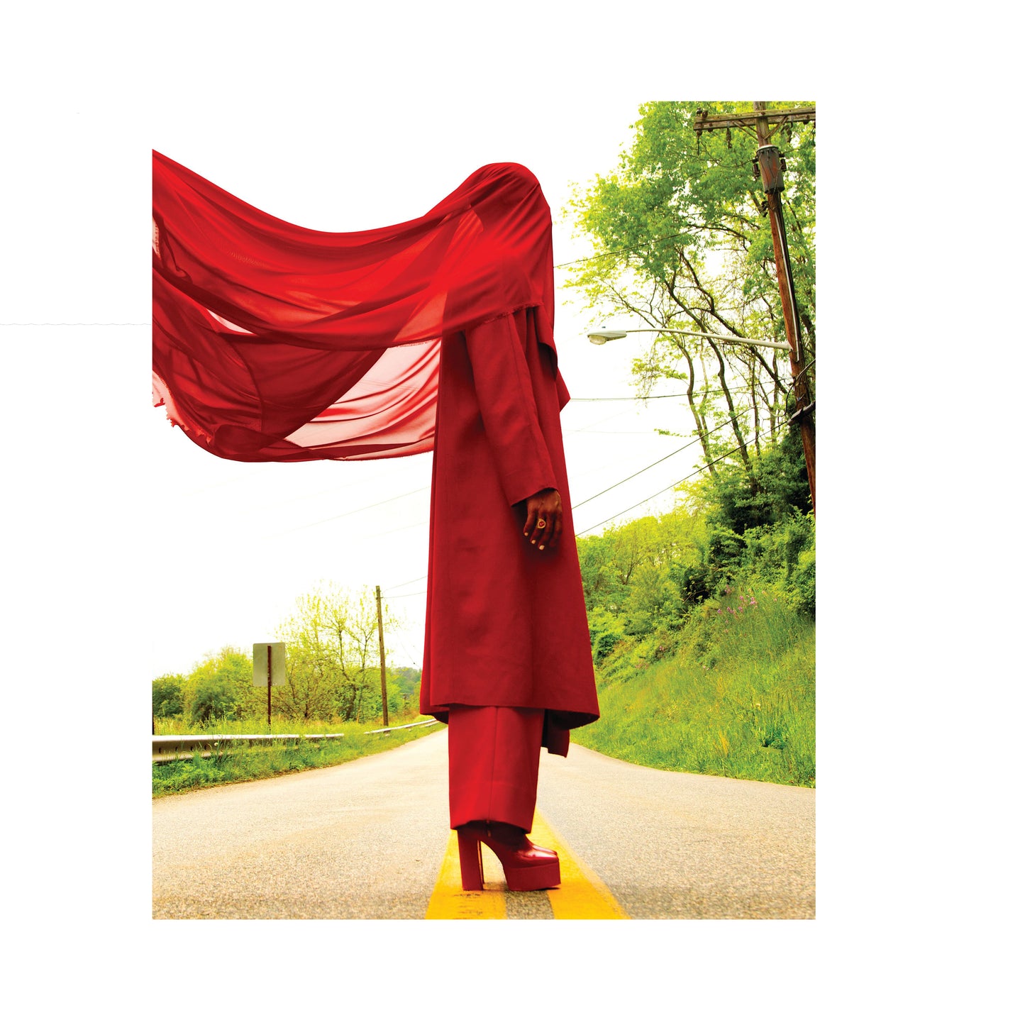 Man wearing boxy red double breasted coat with his face covered by a red scarf