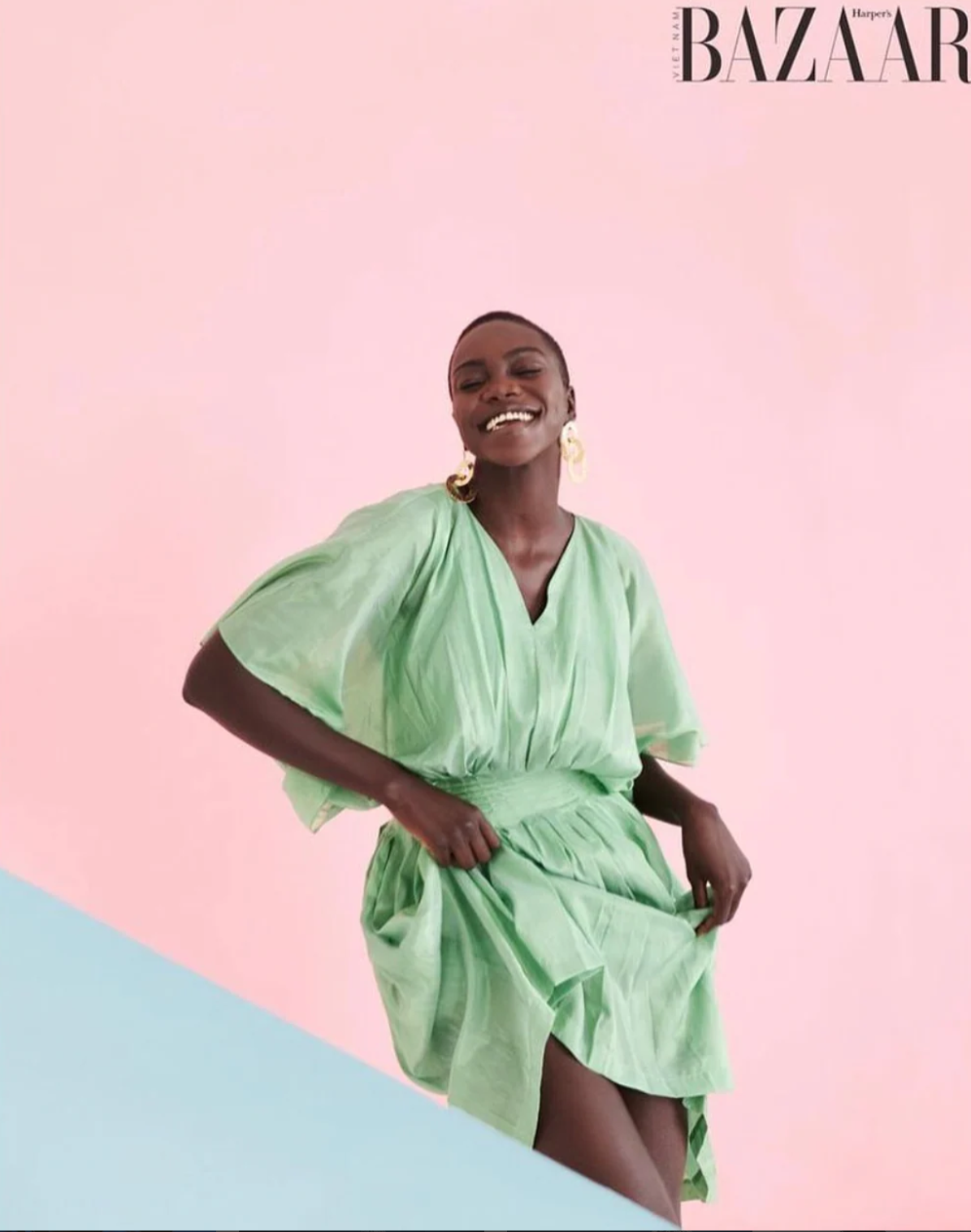 Smiling woman wearing a loose iridescent green v neck dress.