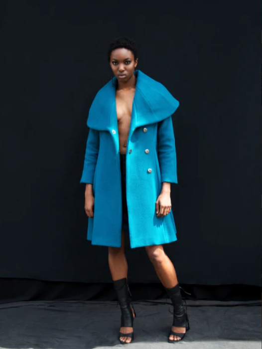 Woman standing wearing a long teal cape collared coat that is unbuttoned.

photographer Sean P. Watters @swatters creative hair, Mua and styling by @ecoconyc modeled by the gorgeous @francescaoyeleke