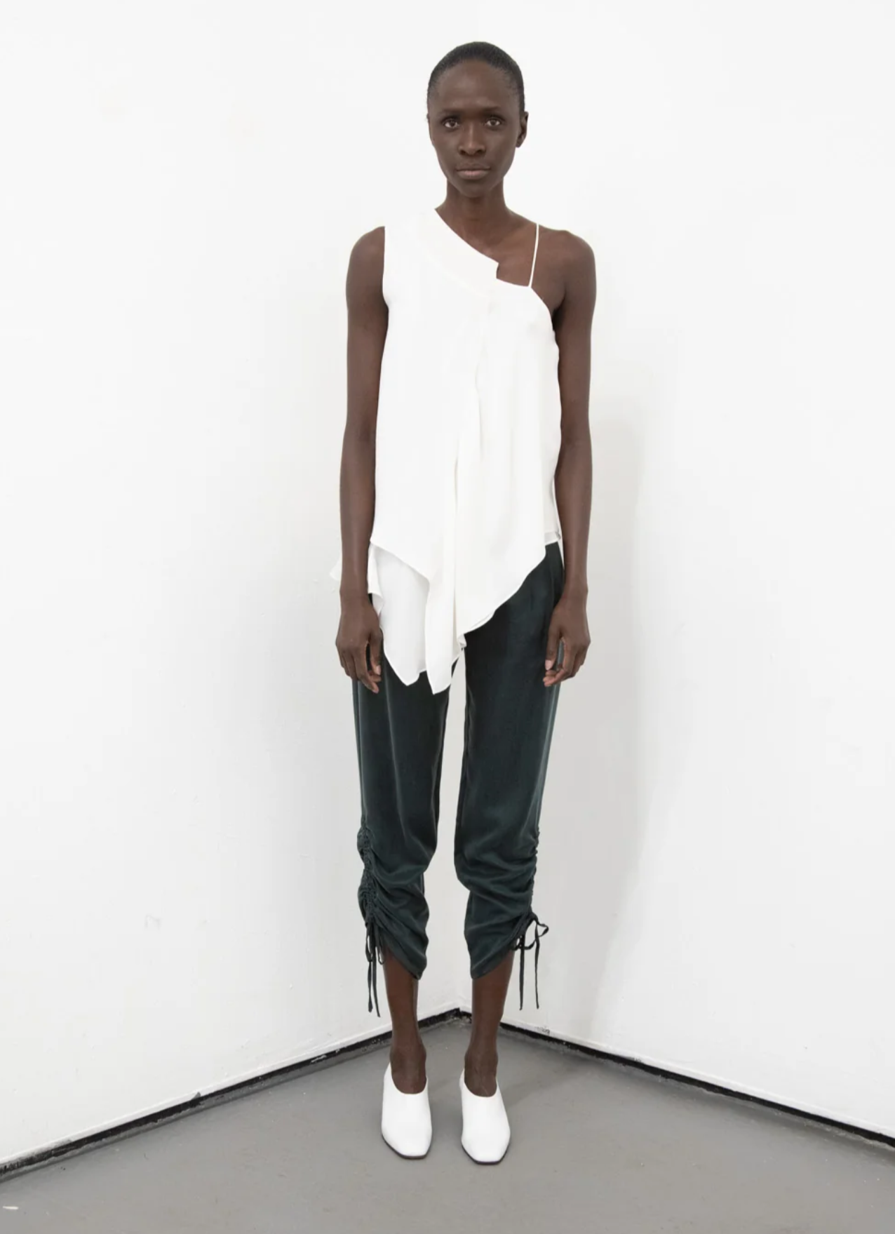 A model wearing Pants with contoured waist band and side drawstring detail in Black