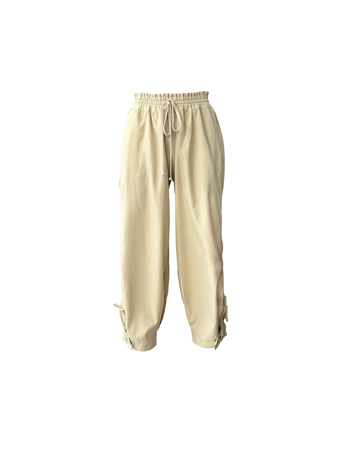 Beige drawstring pants with a relaxed, baggy fit and adjustable cuffs