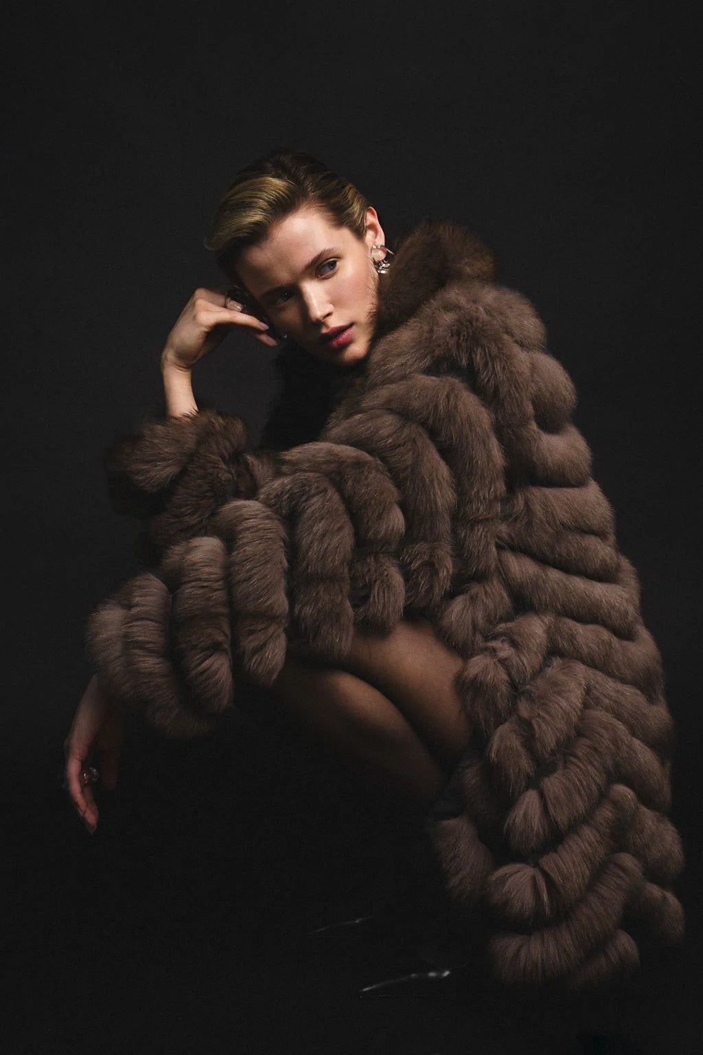 Woman wearing a fox fur coat squatting with her head leaning on one hand.

Credits: Designer: @heike_ny 
Wardrobe Stylist: @styledbynikolett Photographer: @shamayim Production Assistant: @monicaemcghee Accessories: @shopmeyvn Model: @veronicasandae Model: @fernandovaldez__ Makeup and Hair: @alexandraosipovamakeup Black Sheer top: @shacaro.official