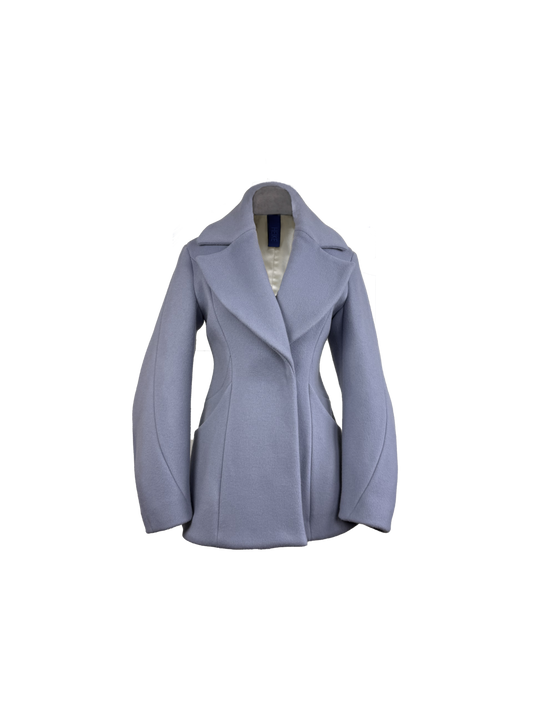 A light periwinkle blue tailored coat with wide lapels, barrel sleeves, and structured shoulders