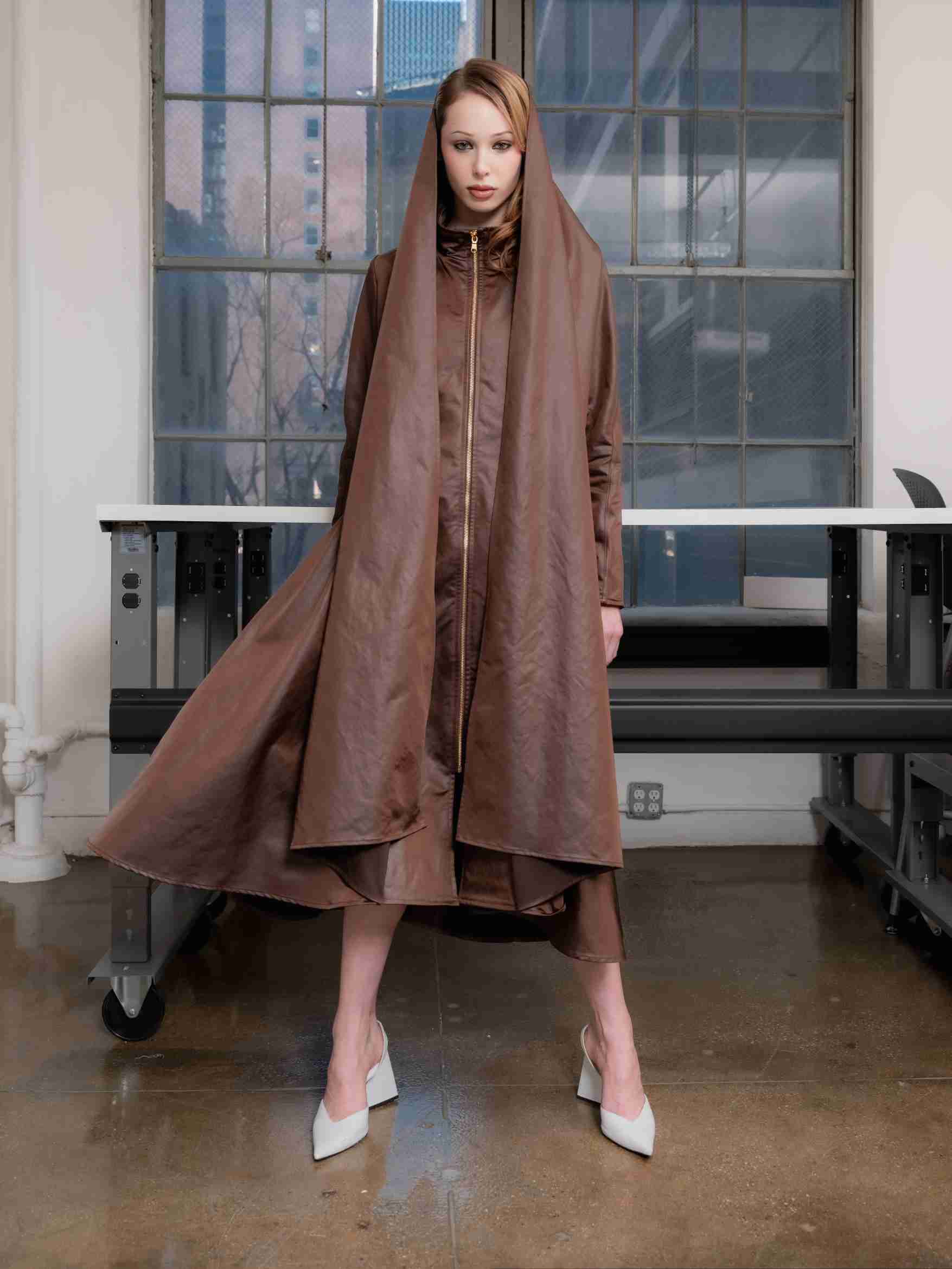 Woman wearing a chocolate satin martine coat standing straight and posing in front of a window.

@natalieturnerr captured beautifully by @_vazhak_ creative eye @kent.nycfashion
@makohairmakenyc
@gabriel.barse
@suecandia
@the_confessional_showroom_ny
@confessional_showroom_miami